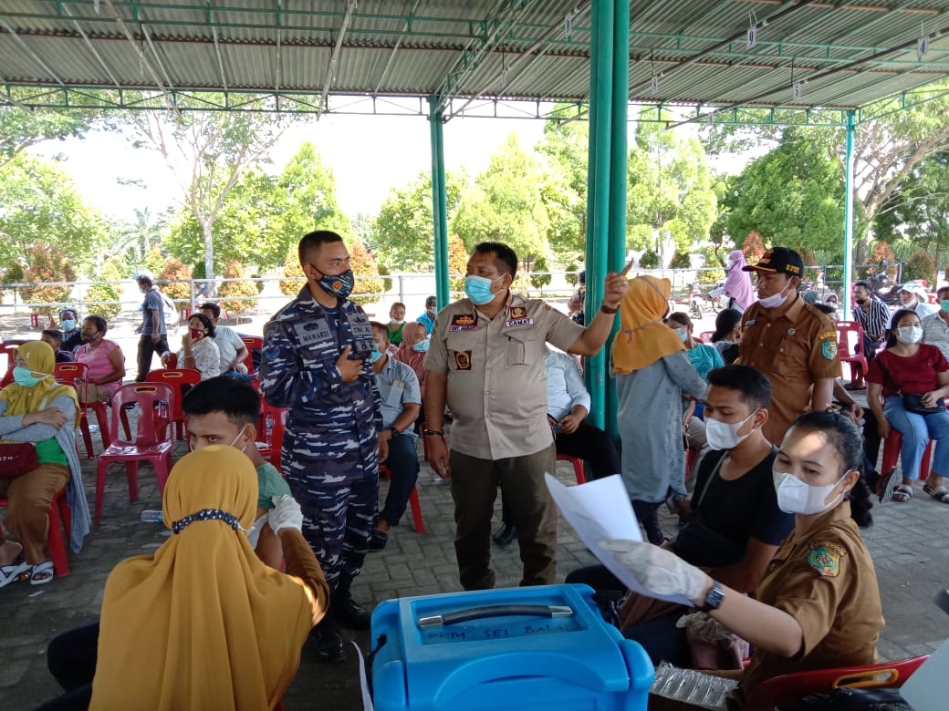 Camat Sei Balai KRT Hanafi, S.H bersama Babinpotmar Posal Tanjung Tiram Kopda Mar Mawardi saat meninjau serbuan vaksinasi massal di halaman Singapur Land.