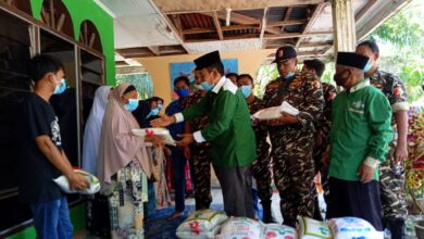 Ketua NU Batubara H. Bakhtiar Mogaza S. Pd, M. Hum beserta Banser Ansor saat menyalurkan paket sembako (beras) kepada warga terdampak banjir di Desa Perjuangan Kecamatan Sei Balai Kabupaten Batubara