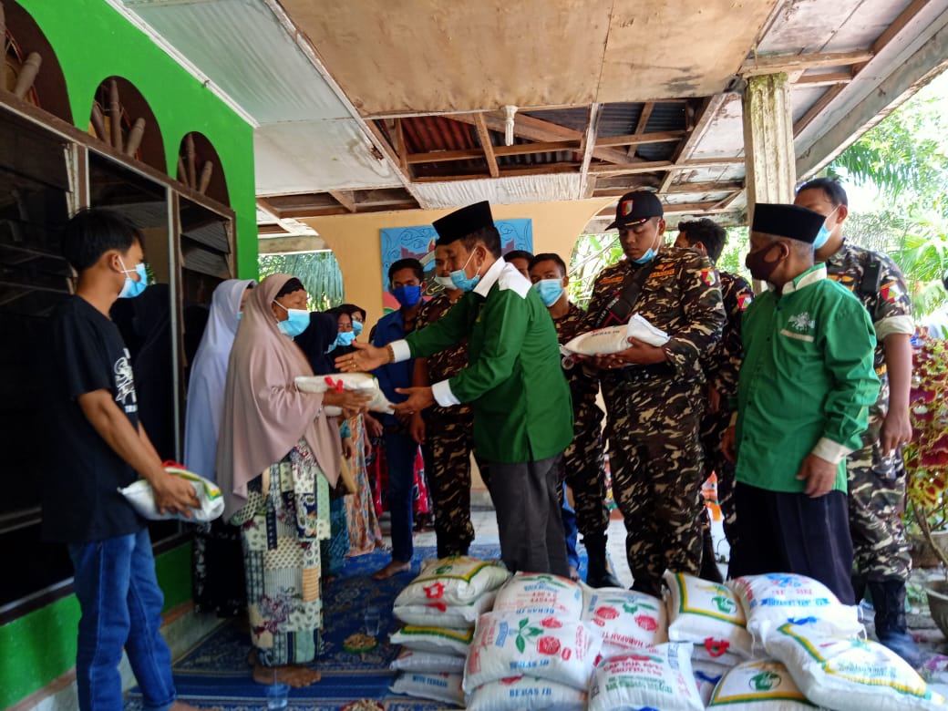 Ketua NU Batubara H. Bakhtiar Mogaza S. Pd, M. Hum beserta Banser Ansor saat menyalurkan paket sembako (beras) kepada warga terdampak banjir di Desa Perjuangan Kecamatan Sei Balai Kabupaten Batubara