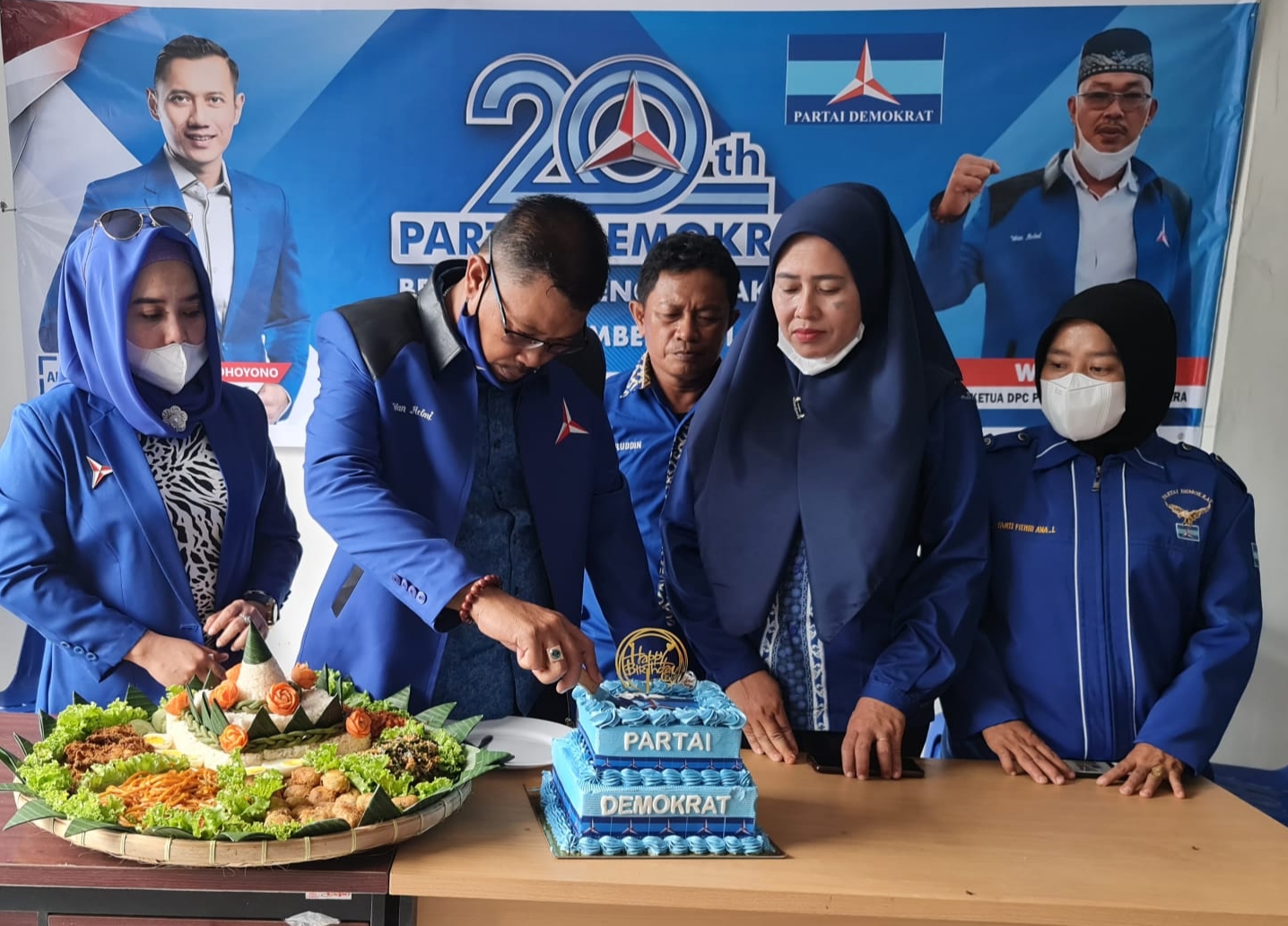 Ketua DPC Partai Demokrat Kabupaten Batubara Wan Helmy SE didampingi Sekretaris Sri Wahyuni saat perayaan HUT ke-20 dengan pemotongan kue bolu dan nasi tumpeng.