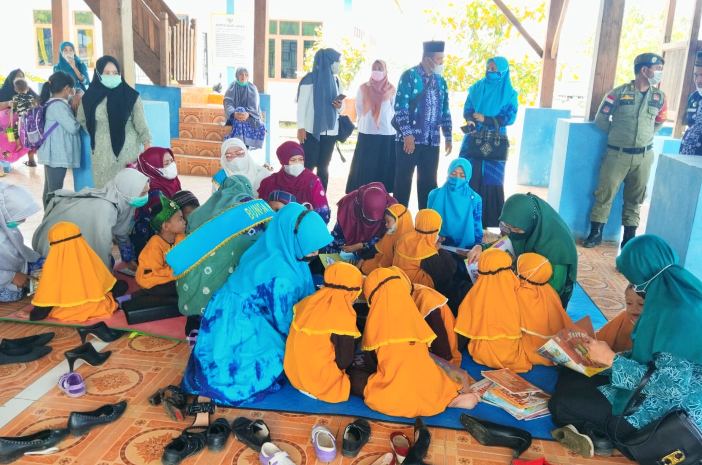 Teks Foto: Bunda PAUD Ny. Maya bersana anak-anak PAUD disela pengukuhan sempatkan diri menyambangi peserta PAUD di Kecamatan Tanjung Tiram saat belajar dari buku-buku Perpustakaan Keliling.