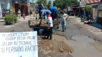 Gabungan tokoh muda dan masyarakat Nibung Hangus saat gotong royong tambal jalanan yang rusak.