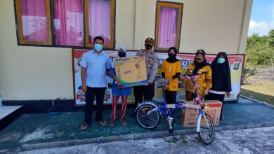 Ketgam: Kapolsek Mastim, Ipda Musrifin di dampingi Camat Mastim, Fitri Aisa Syam saat memberika hadiah kepada warga, Jumat (22/10/2021) (Win/Beritanasional.Id)