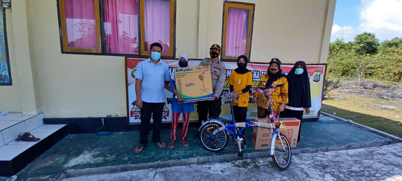 Ketgam: Kapolsek Mastim, Ipda Musrifin di dampingi Camat Mastim, Fitri Aisa Syam saat memberika hadiah kepada warga, Jumat (22/10/2021) (Win/Beritanasional.Id)