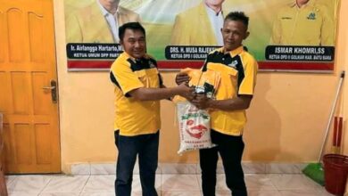 Ismar Khomri, S.S Ketua DPD Golkar Batubara saat memberikan seragam Partai kepada Pimpinan Desa Partai Golkar