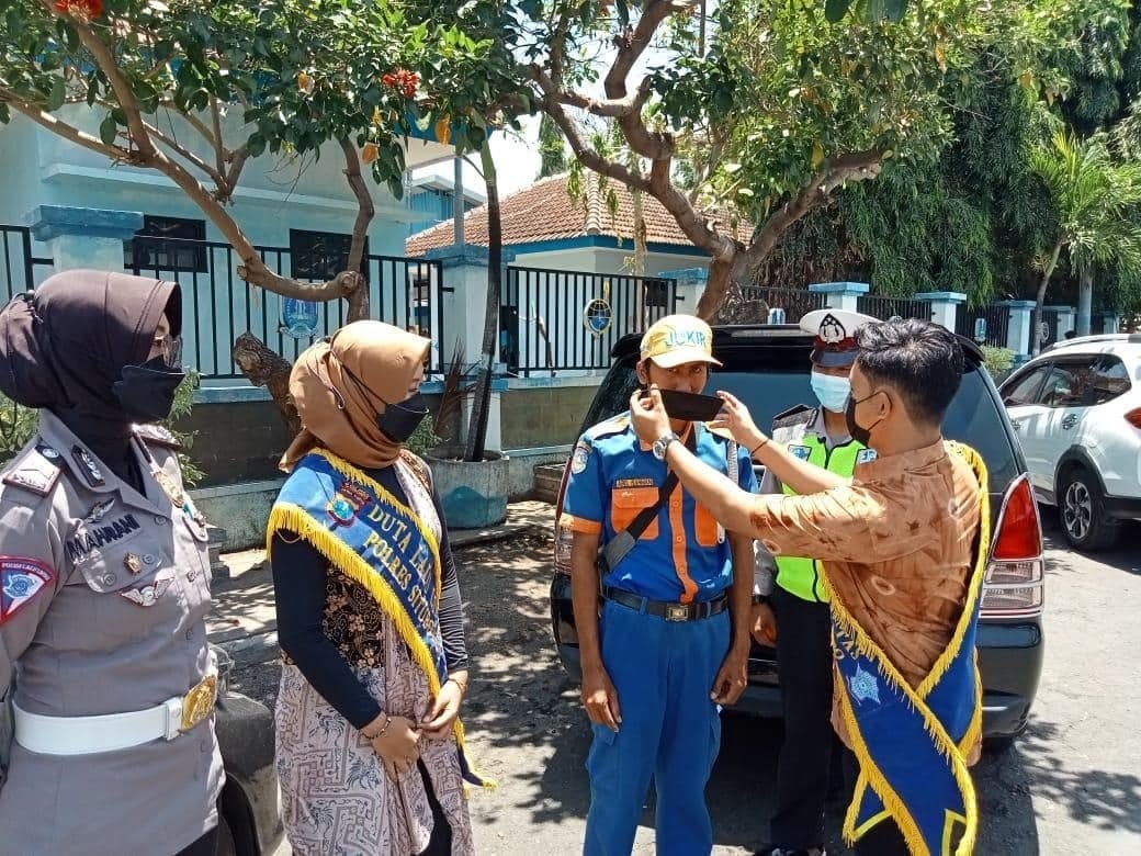 Kasat Lantas Polres Situbondo AKP Anindita Harcahyaningdyah, S.I.K bersama Duta lalu lintas Kabupaten Situbondo membagikan masker terhadap tukang parkir 