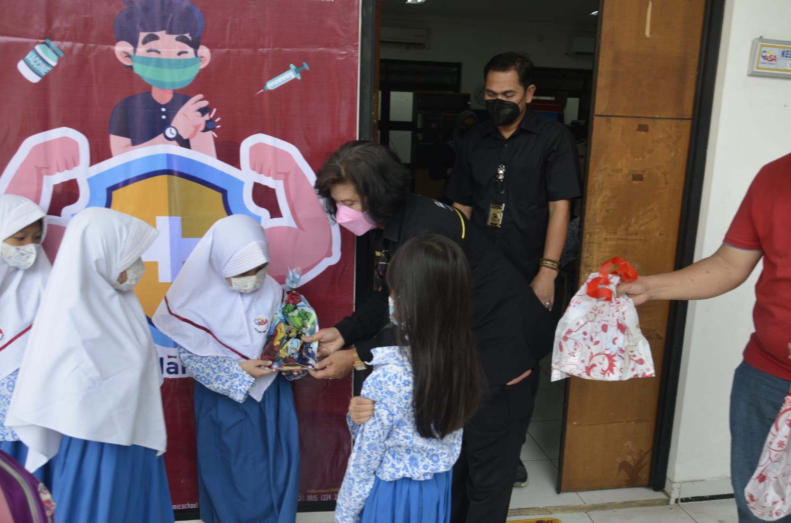 Wakasat Narkoba Kompol. Suwolo Seto bersama Kasi Humas Polres Kompol. Erna Ruswing Andari memberikan hadiah bagi siswa/siswi yang sudah selesai di vaksinasi