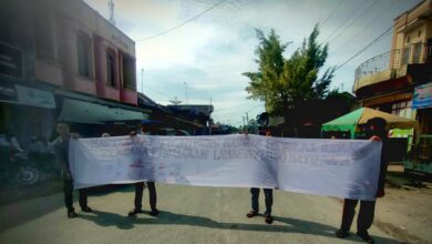 Masyarakat Nibung Hangus di Pusat Kota Desa Ujung Kubu saat membentangkan Kain Putih beserta tanda tangan masyarakat yang menolak rencana perubahan lambang Daerah tersebut. (Doc: Ist)