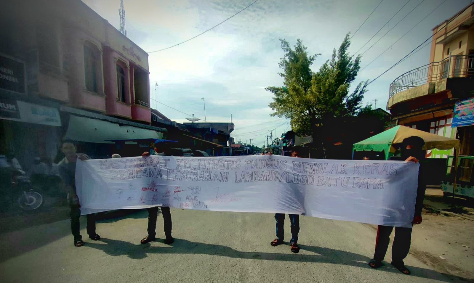 Masyarakat Nibung Hangus di Pusat Kota Desa Ujung Kubu saat membentangkan Kain Putih beserta tanda tangan masyarakat yang menolak rencana perubahan lambang Daerah tersebut. (Doc: Ist)