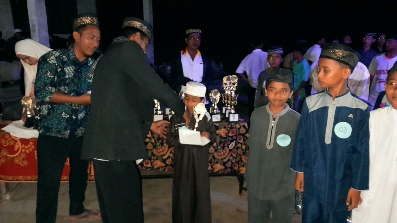 Teks foto: Ketua PC Al-Wasliyah Nibung Hangus Syafii Hidayatullah, S.Pd. I sekaligus penceramah, saat memberikan piala pada siswa disela peringatan Isra' Mi'raj 1443 H/2022/M. (Ali/02)