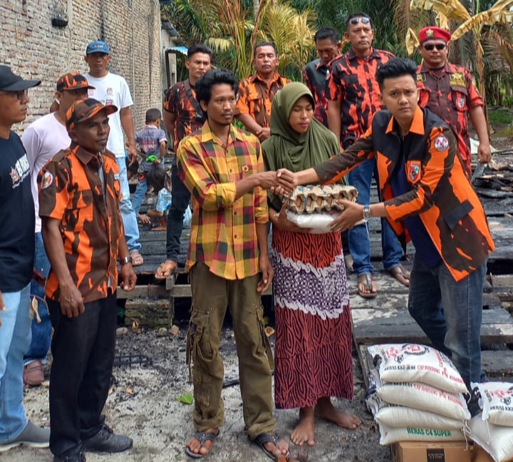 Ketua PAC PP Nibung Hangus, M. Ridwan saat memberikan bantuan sembako terhadap korban kebakaran di Desa Patang Rambai.