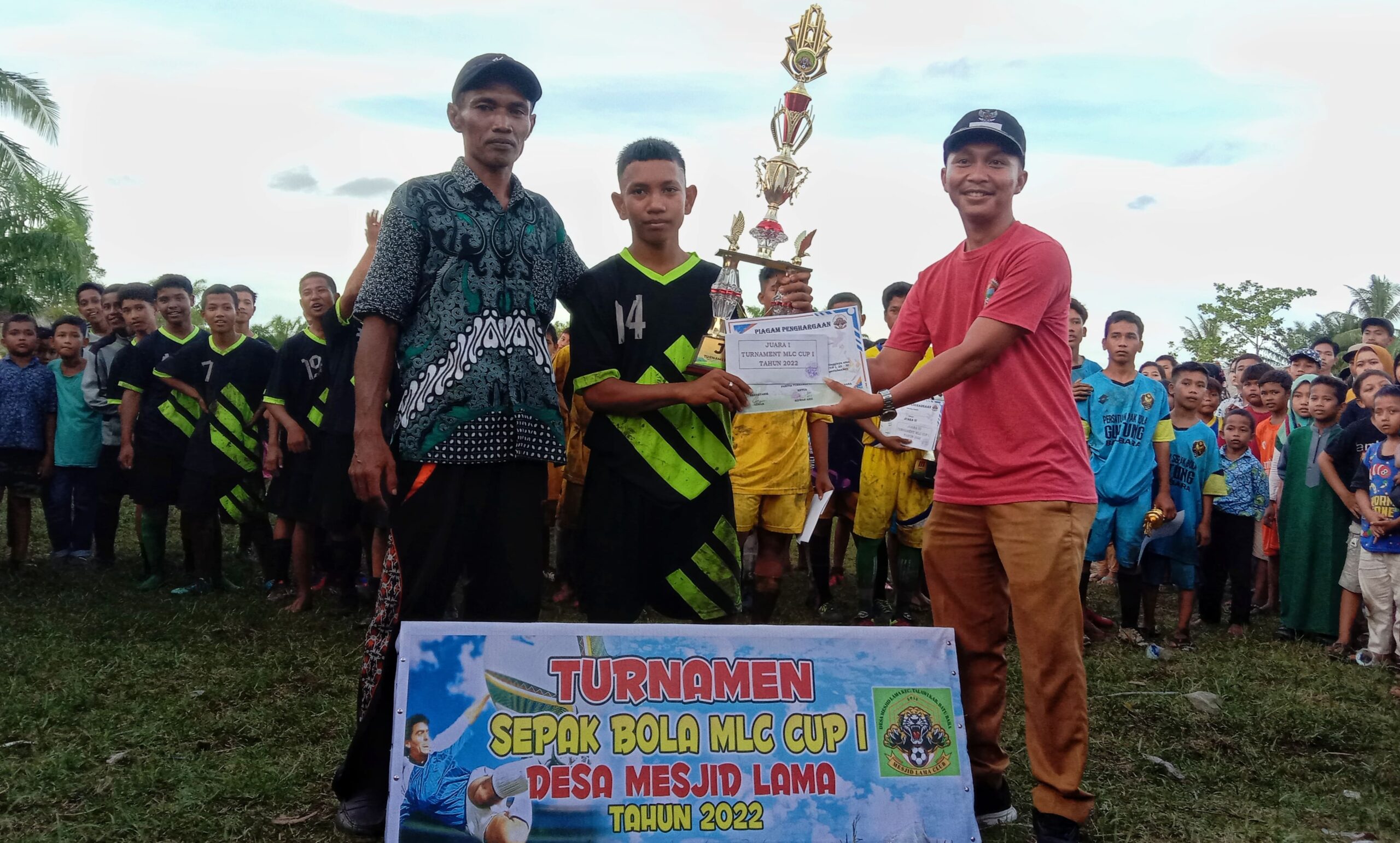 Pemberian piala bergulir MLC CUP I dan penghargaan oleh Ketua Panitia (kiri) bersama salah seorang donatur (kanan) kepada Juara I Al-Mukhlushin FC. (doc; FTR/01)