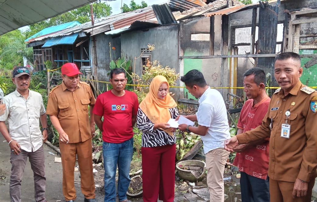 Teks foto: Relawan Kadin Berbagi saat menyerahkan Bantuan Bahan Pangan dan Tali Asih kepada Dewi dan Usman, Korban Kebakaran yang merupakan guru di UPT SDN 11 Tanjung Tiram. (Doc; FTR-01)